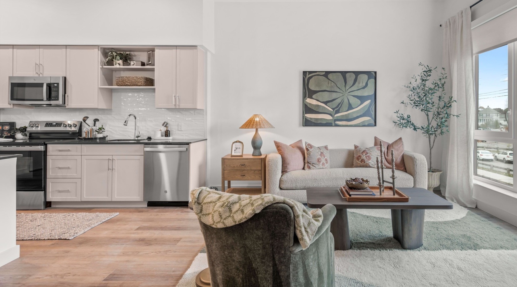 Model living room at Lore Apartments in Salem, MA, featuring wood grain floor paneling and modern decor.