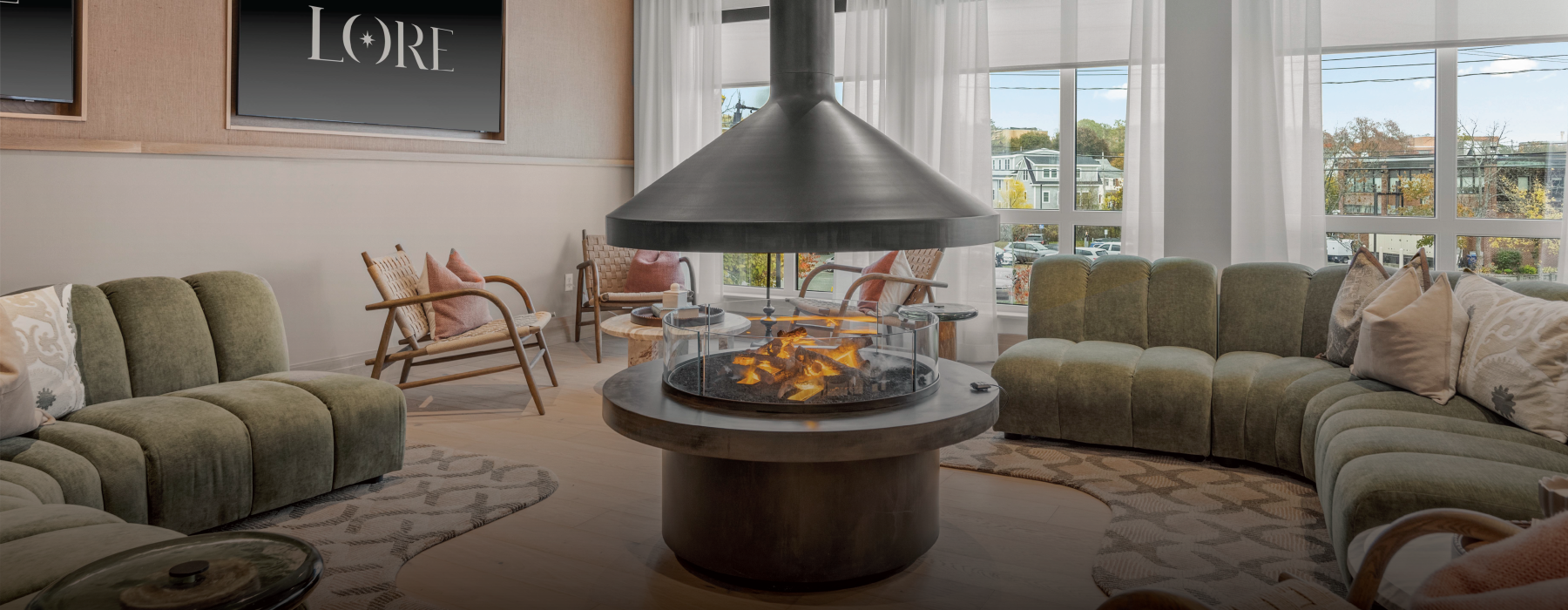 a room with a fireplace, chairs, and a large green couch 