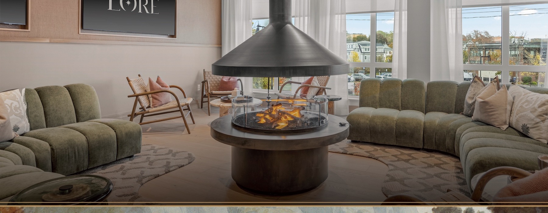 a room with a fireplace, chairs, and a large green couch 